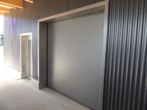 anthrazites Industrietor von einem Geschäftshause in Triengen