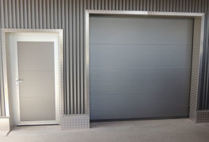 anthrazites Industrietor mit einer Eingangstür daneben