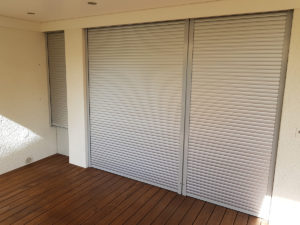 drei unterschiedlich grosse Fenster, welche mit geschlossenen Rolladen bedeckt sind.