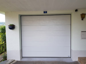 die Aufnahme zeigt ein weisses Sektionaltor, welches zum Einfamilienhaus in Rickenbach gehört