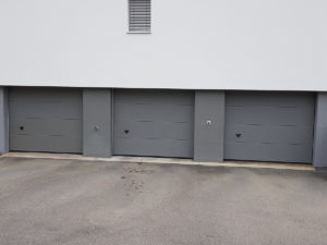 drei dunkelgraue Sektionaltor vom Mehrfamilienhaus in Triengen