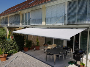 Zusehen ist der Gartenplatz von einem Einfamilienhaus in Horw, welcher von einer Sonnenstore geschützt wird.